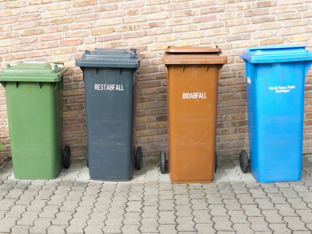Vier Mülltonnen vor einer Hauswand